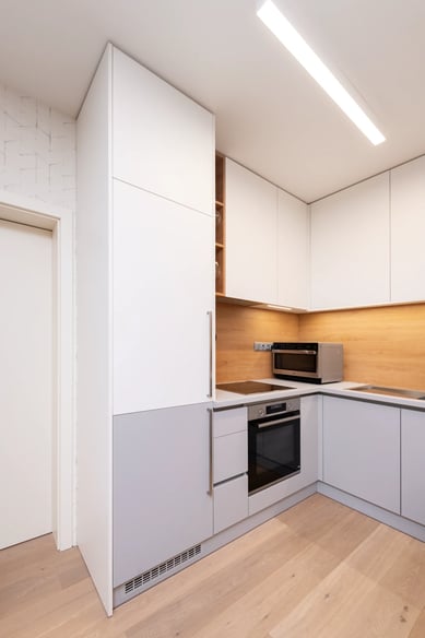 Minimalistická kuchyně bílá šedá dřevo spotřebiče